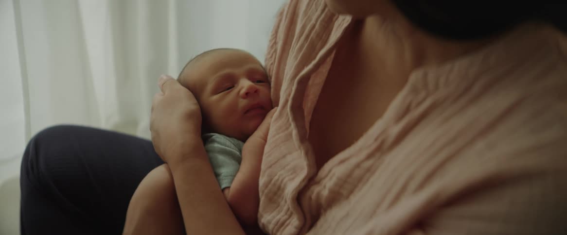 Mother sited on the bed tending to her child