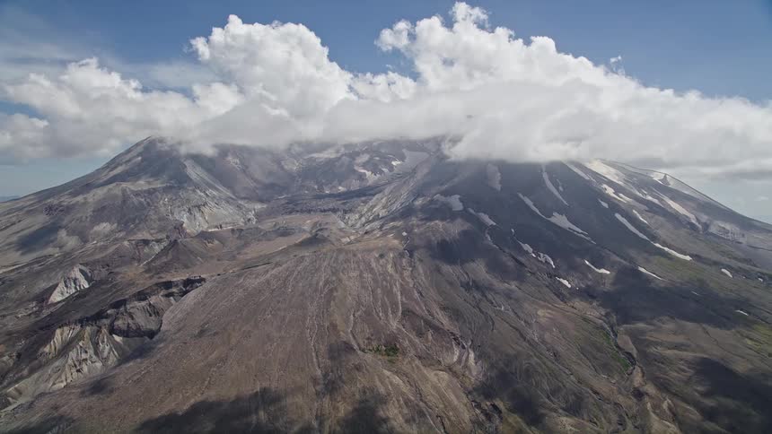 Aerial view of Mount St Helens crater and cloud cover in Washington showcasing the majestic peaks of the Cascade Mountains amidst partly cloudy skies