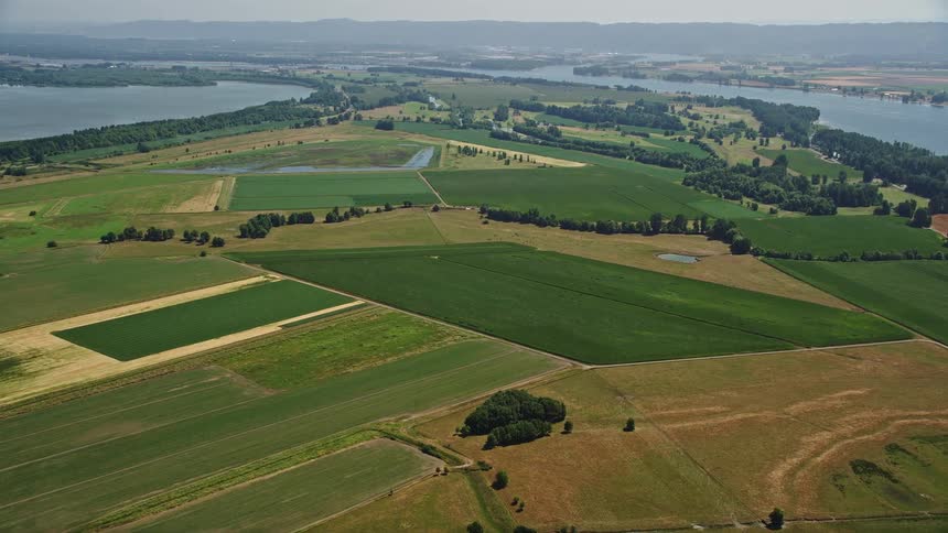 Aerial view of wide green farm fields in Vancouver Washington with a nearby river