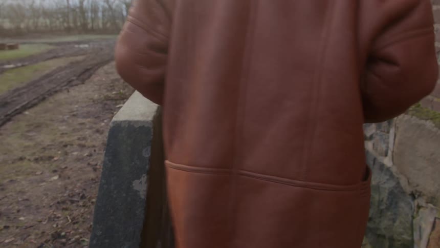 One woman offloads tiles from a truck and hands them to another woman