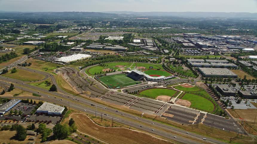 Aerial view of a multi-sport stadium in Hillsboro Oregon as the camera approaches with the sunny skyline in the background