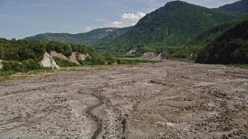  aerial footage captures a low flight over the North Fork Toutle River sediment in Washington on a sunny day showcasing the natural beauty of the river and surrounding landscape
