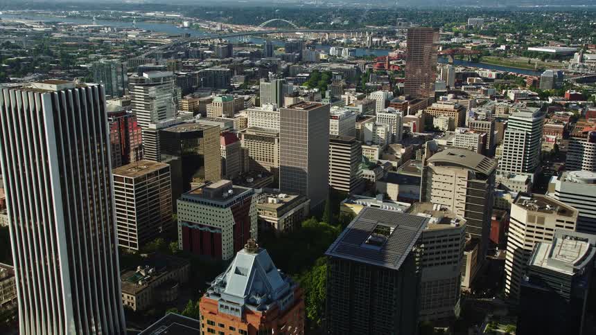 Aerial flyover of downtown Portland Oregon with its high-rise buildings and skyscrapers on a sunny day