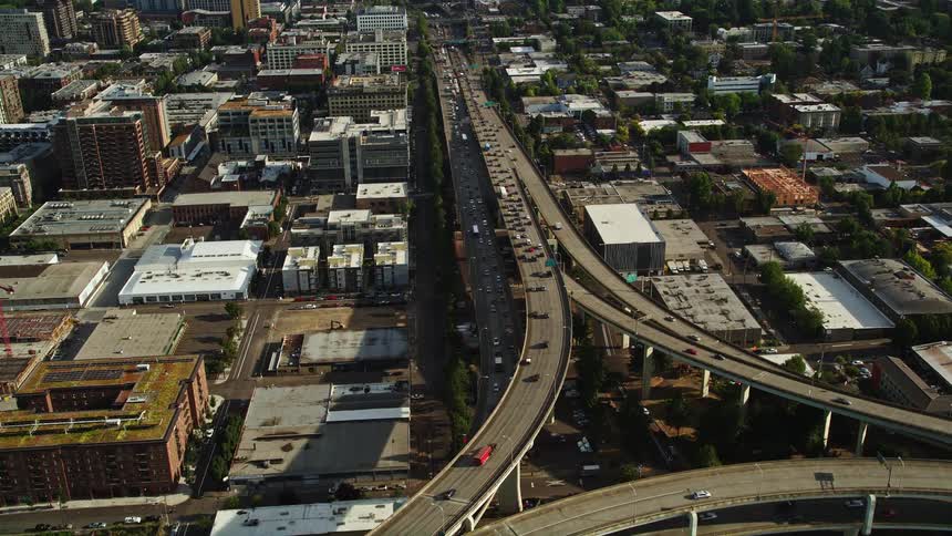 Aerial footage captures heavy traffic on the busy highways of downtown Portland Oregon as it intersects with Highway 30 and Interstate 405 surrounded by blocks of apartment buildings