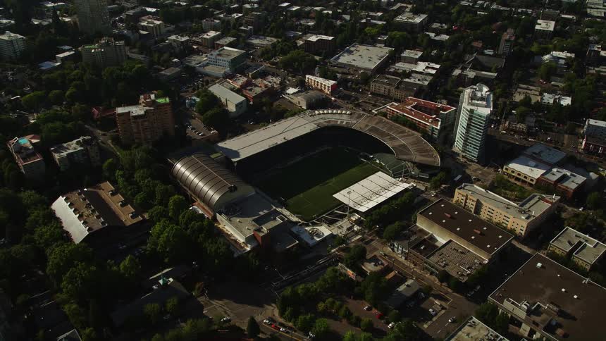 Aerial view of Providence Park a soccer field in downtown Portland Oregon surrounded by cityscape and blue sky
