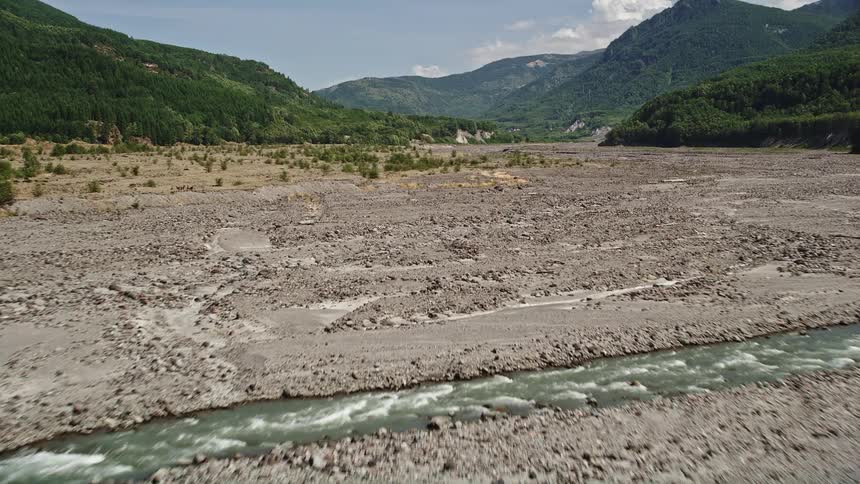 Aerial view of low flight over the North Fork Toutle River approaching Mount St Helens Washington on a sunny day
