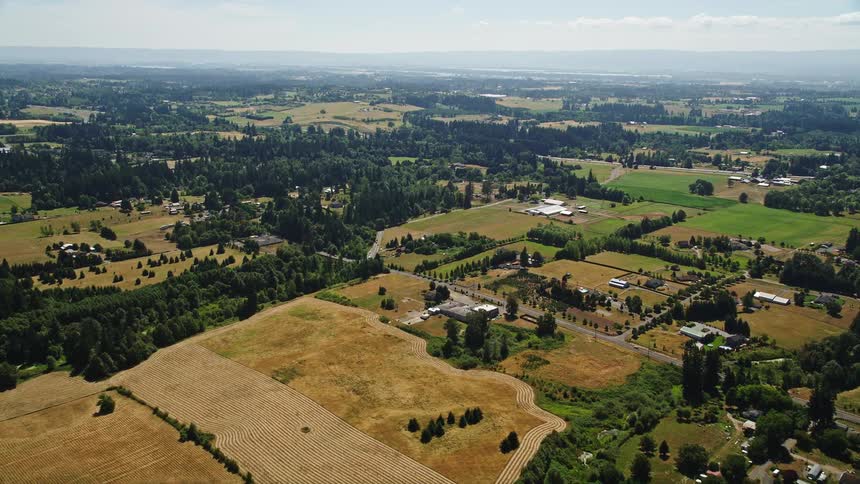 Aerial footage showcasing the green and brown farm fields in Ridgefield Washington during the day