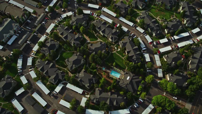 Aerial footage pan and tilt to a bird's eye view of an apartment building complex in Hillsboro Oregon with sunny weather and residential neighborhood