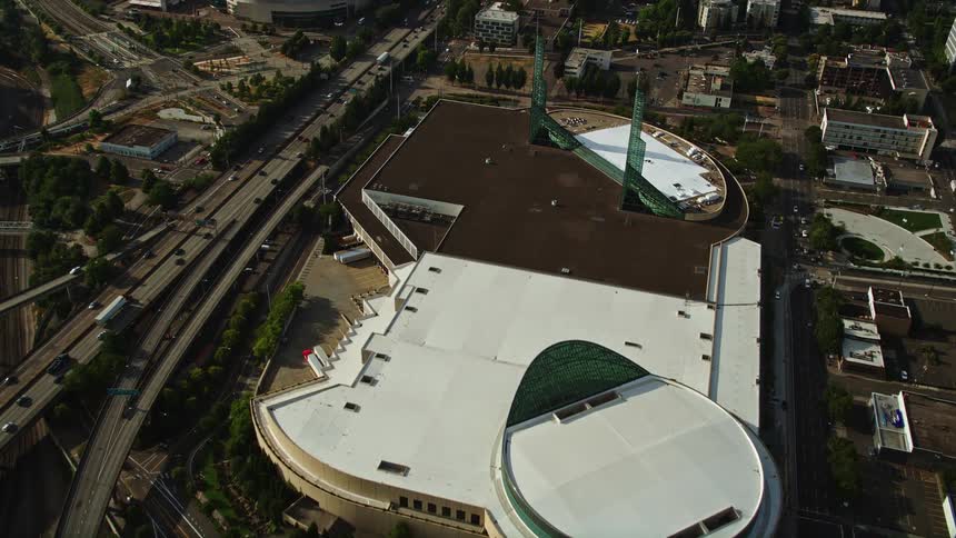 Aerial view of the Oregon Convention Center in Portland as seen from the Willamette River with beautiful sunshine and the city's skyline in the background