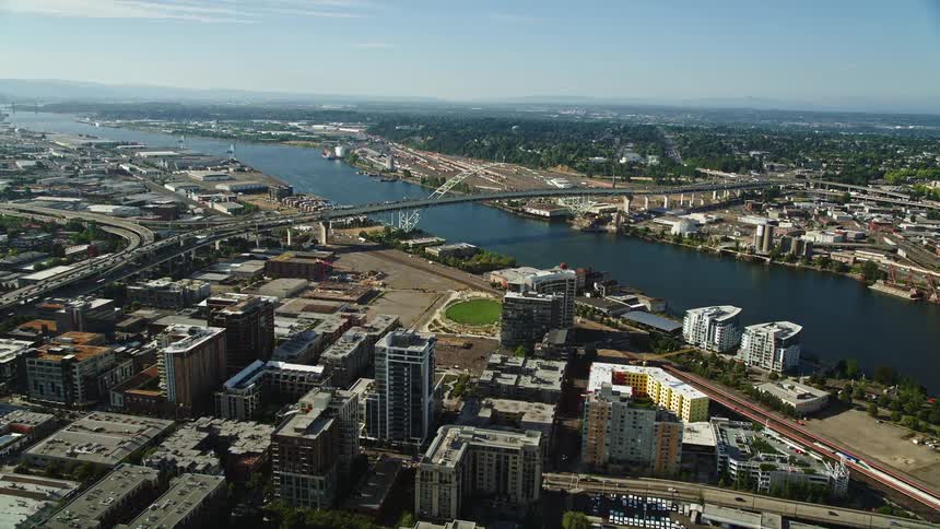 Aerial footage of a sunny day approaching and orbiting the Fremont Bridge and Willamette River in Downtown Portland Oregon