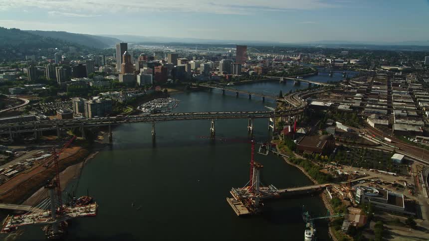 Aerial footage of downtown Portland buildings along the Willamette River showcasing the city's high-rise towers and bridges