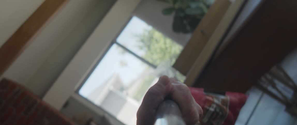 Elderly man lifting a bag of potatoes attached to a bar indoors during day time