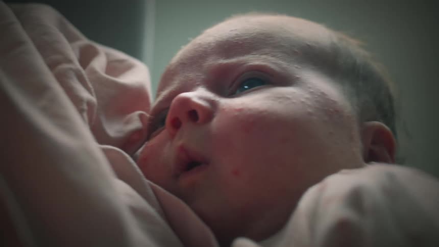 Mother rocks with baby in her arms