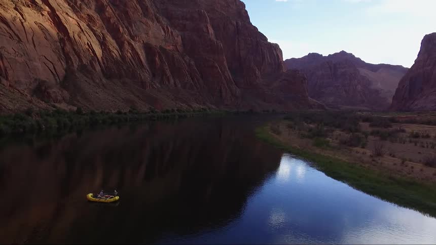 A yellow raft in a lake near a mountain