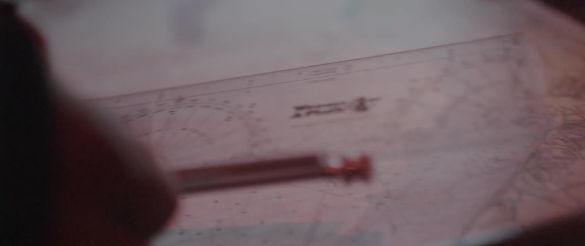 A person picks up an instrument and looks at a map
