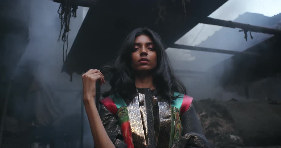 A model poses in a run down smoke filled building