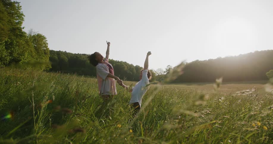 Couple Dancing Man proposing to his partner and then lifting her up happily in a field