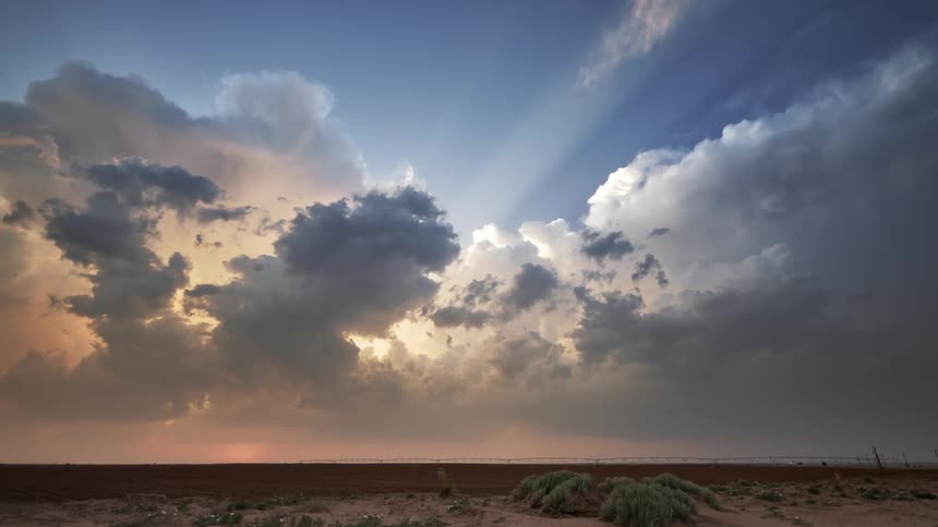Crepuscular rays over rolling clouds in the desert at sunset