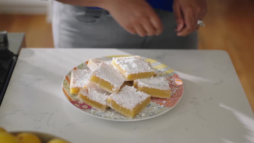 Woman placed a plate of cake on the table in the sitting room