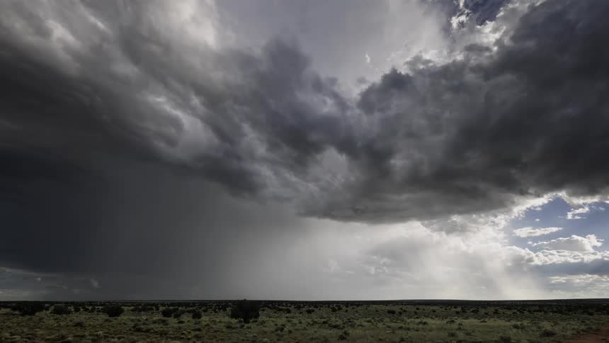A gray storm cloud stretches across the sky over a flat region