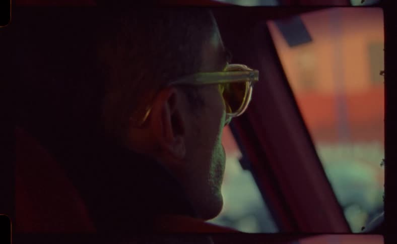 Profile of a man wearing glasses sitting on a car