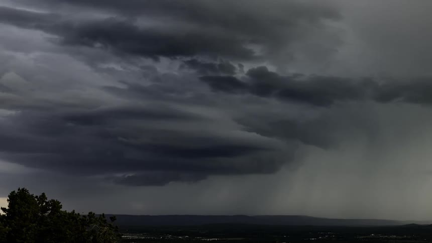 Heavy storm clouds pour rain and lightning from the clouds