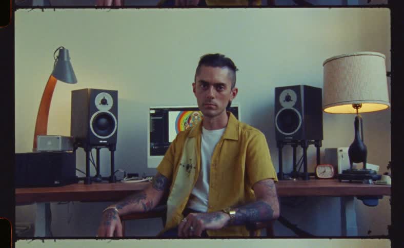 A man in a yellow jacket is sitting and suddenly turns around