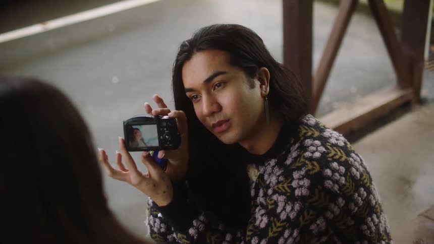 A teenager takes a photo and talks
