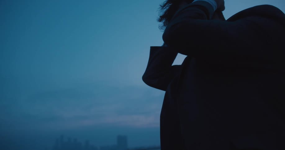 A distraught businessman puts his hands on his head and is looking sad and desperate