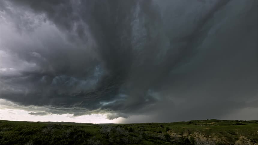 A gray colored tornado cloud circling a region in the sky