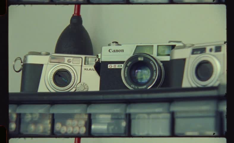A shelf with several cameras of old models