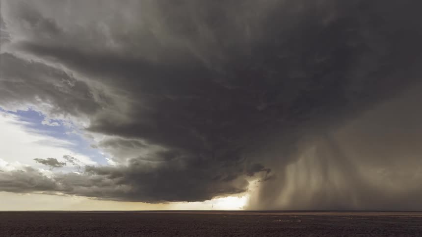 Dark storm clouds gather in the sky over field
