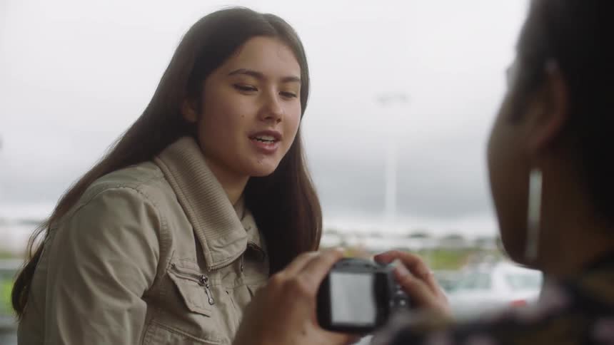 Two friends take photographs of each other with the camera