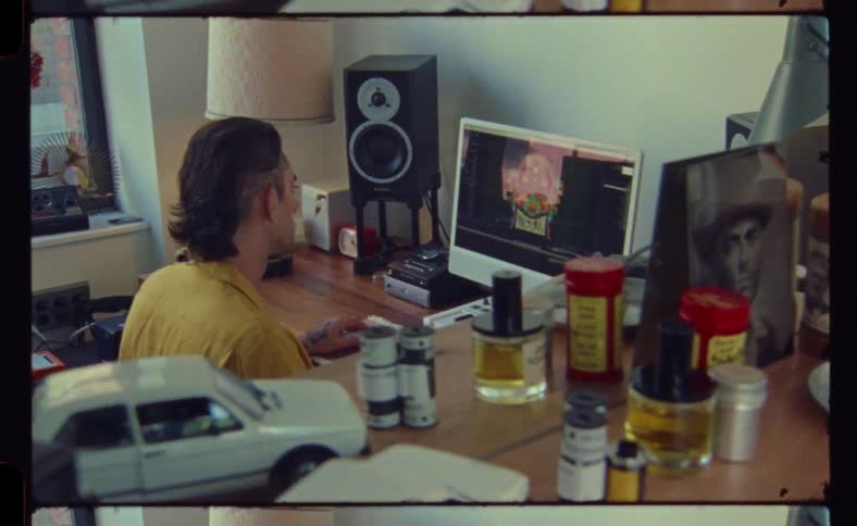 A man is typing at his keyboard by the computer