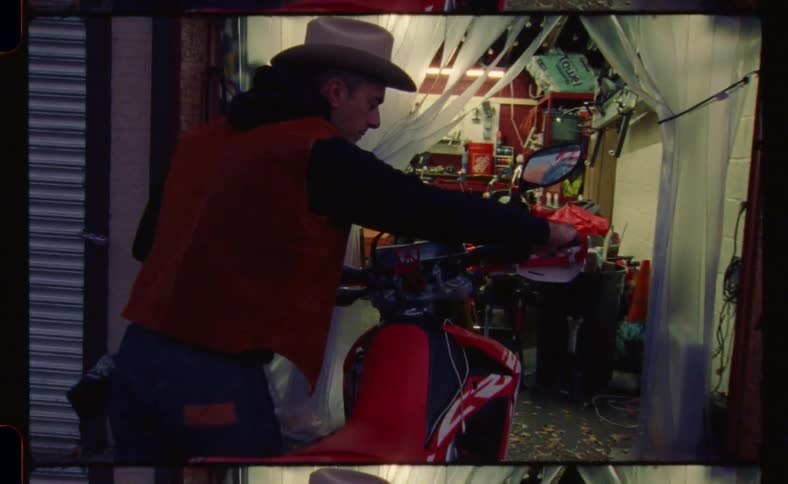 Man moves a red motorcycle from a shop to the street