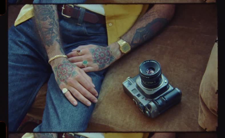 A man is sitting on the couch by his camera