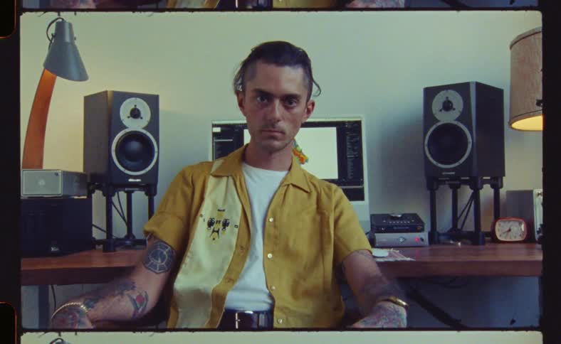A man is posing in front of his computer