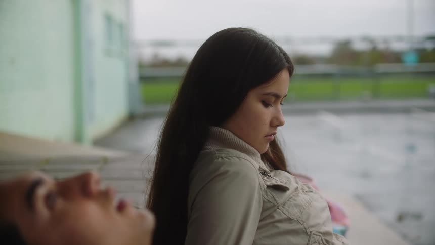 Two young girls are talking on a rainy day