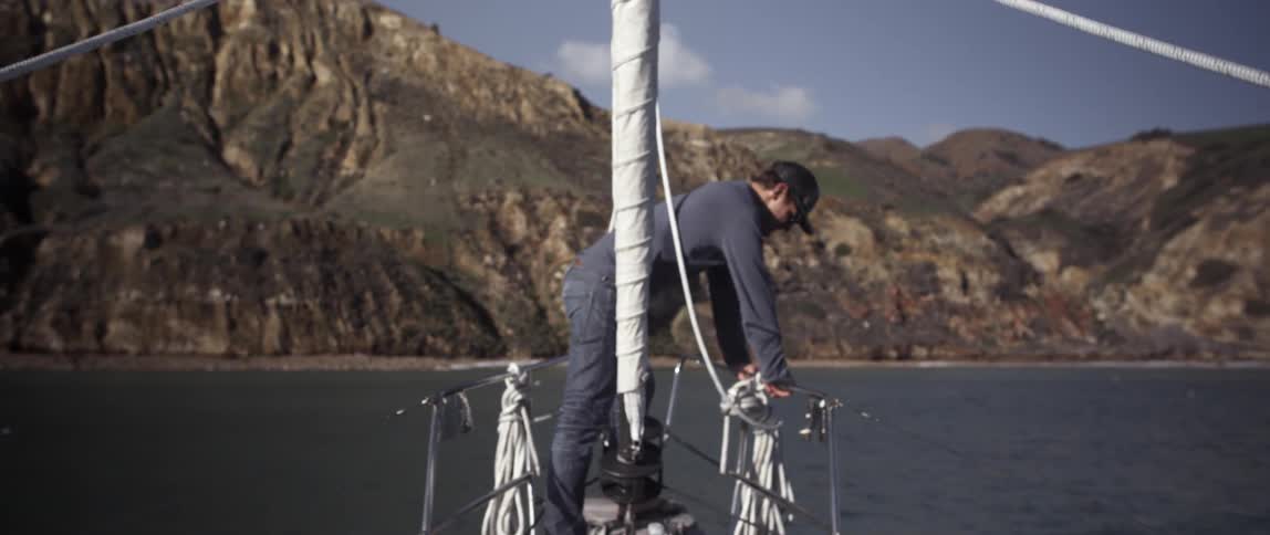 A man is leaning on the railing of a boat