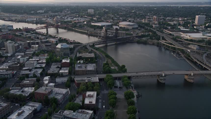 Aerial footage at sunset of traffic running on bridges spanning the Willamette River near Memorial Coliseum and Moda Center in downtown Portland Oregon