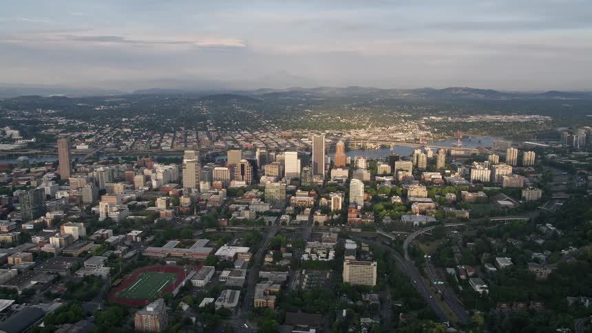 Aerial view of downtown Portland's high-rise buildings and the Willamette River at sunset