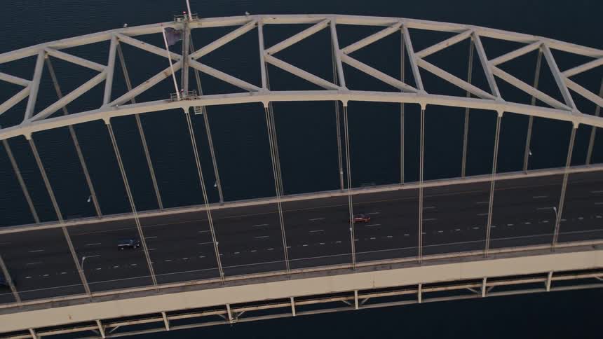 Aerial footage of downtown Portland's Fremont Bridge at sunset showcasing the city's transportation infrastructure and the American flag flying atop the bridge