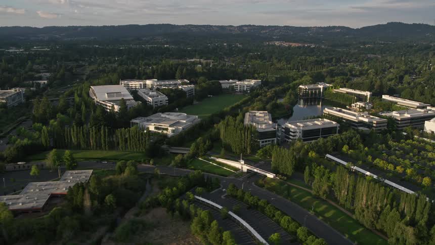 Aerial footage of Nike Headquarters in Beaverton Oregon at sunset showcasing the surrounding office buildings and industrial area