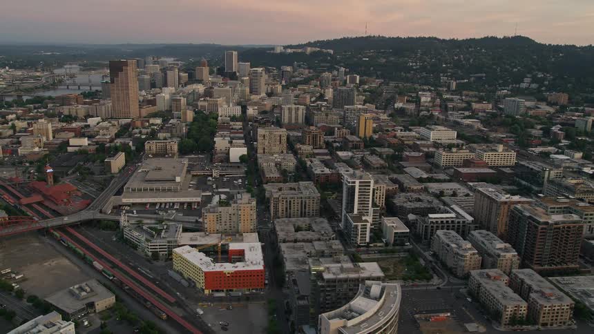 Aerial footage of Downtown Portland Oregon during twilight showcasing the high rise buildings and cityscape