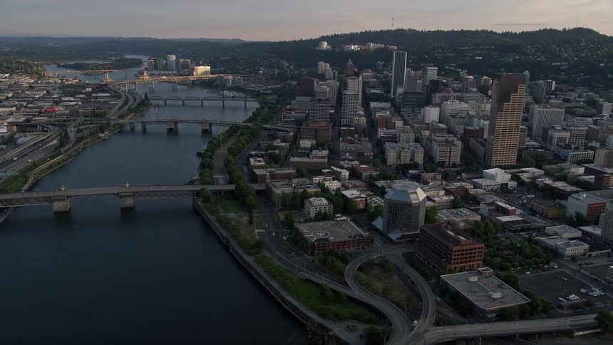 Aerial view of downtown Portland Oregon at sunset showcasing the city's bridges spanning the Willamette River and the bustling metropolis below