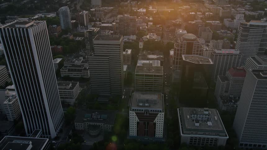 Aerial footage of downtown Portland at sunset overlooking the Willamette River and Hawthorne Bridge showcasing the city's high rises transportation and beautiful natural surroundings