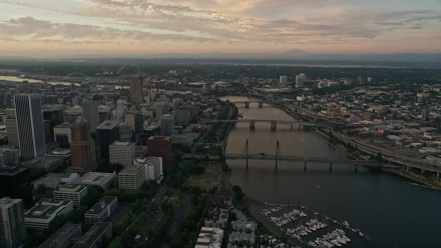 Aerial footage at twilight of Downtown Portland Oregon as the camera follows the Willamette River over bridges