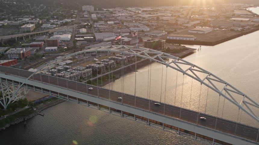 Aerial footage of sunset over Downtown Portland Oregon revealing the Fremont Bridge and the city's skyscrapers along the waterfront