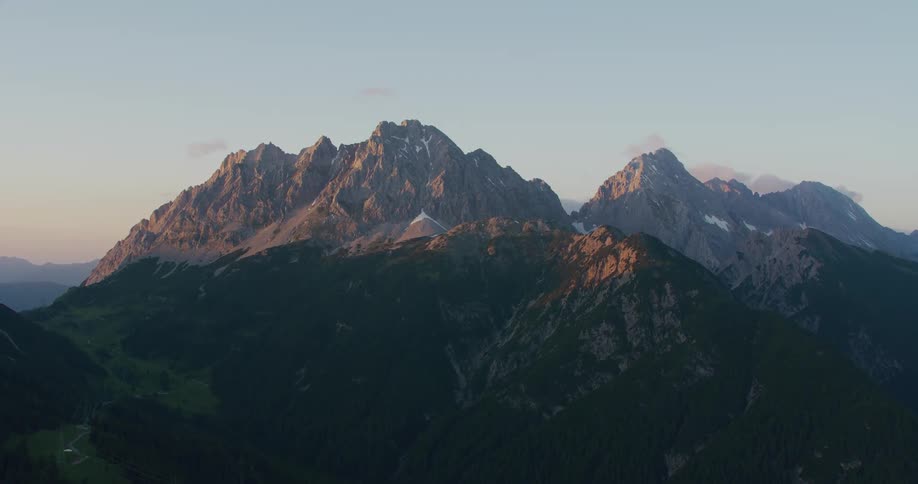 Sunlight shines on top of mountain range on misty day