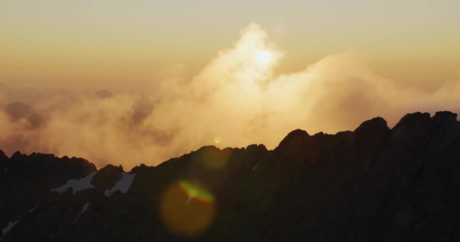 During early spring the sun sets gracefully behind the majestic mountains casting a warm golden glow over the landscape the remnants of snow can still be seen in patches on the mountain slopes